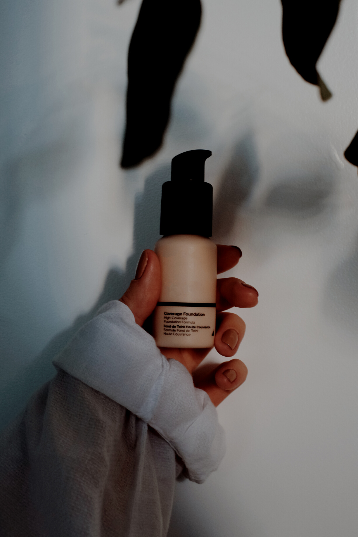 Woman holding beauty product in pump bottle